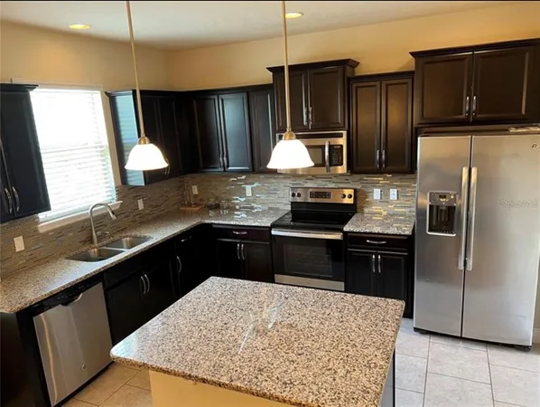 a kitchen with a dining table cabinets and stainless steel appliances