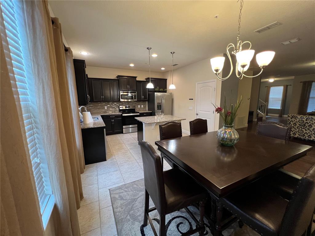 10742 Sunset Ridge Lane Orlando, FL 32832 - Photo 9 of 40 a kitchen with a dining table cabinets and stainless steel appliances