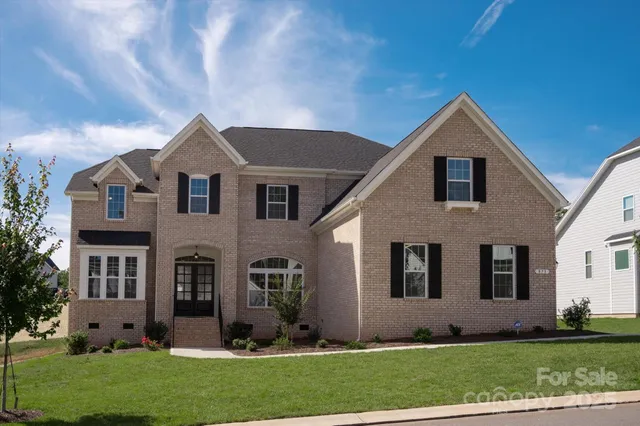 a front view of a house with a yard and trees