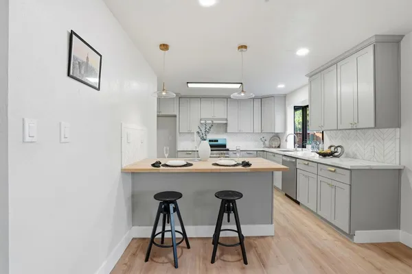 a kitchen with white cabinets and chairs
