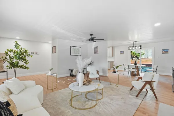 a living room with furniture kitchen view and a potted plant