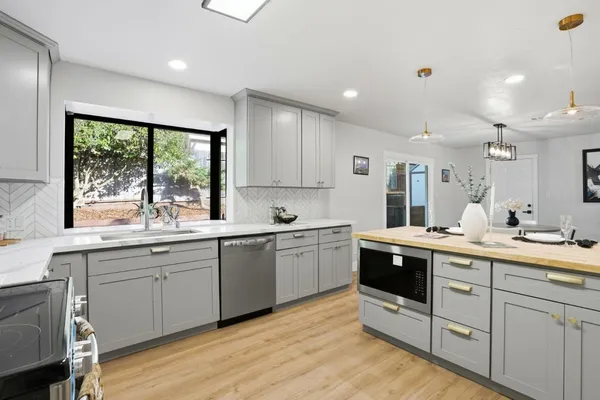 a kitchen with sink stove and cabinets