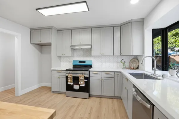 a kitchen with stainless steel appliances granite countertop a sink stove and refrigerator