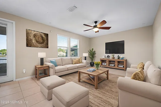 a living room with furniture a ceiling fan and a window