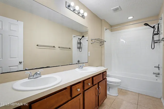 a bathroom with a granite countertop sink a toilet a mirror and shower