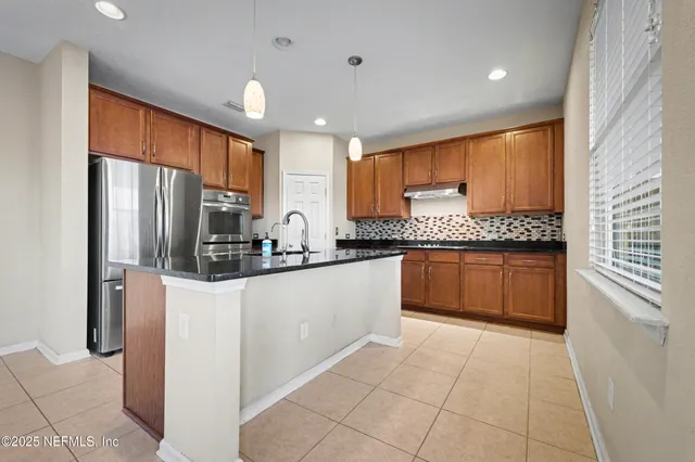 a kitchen with stainless steel appliances granite countertop a refrigerator sink and cabinets
