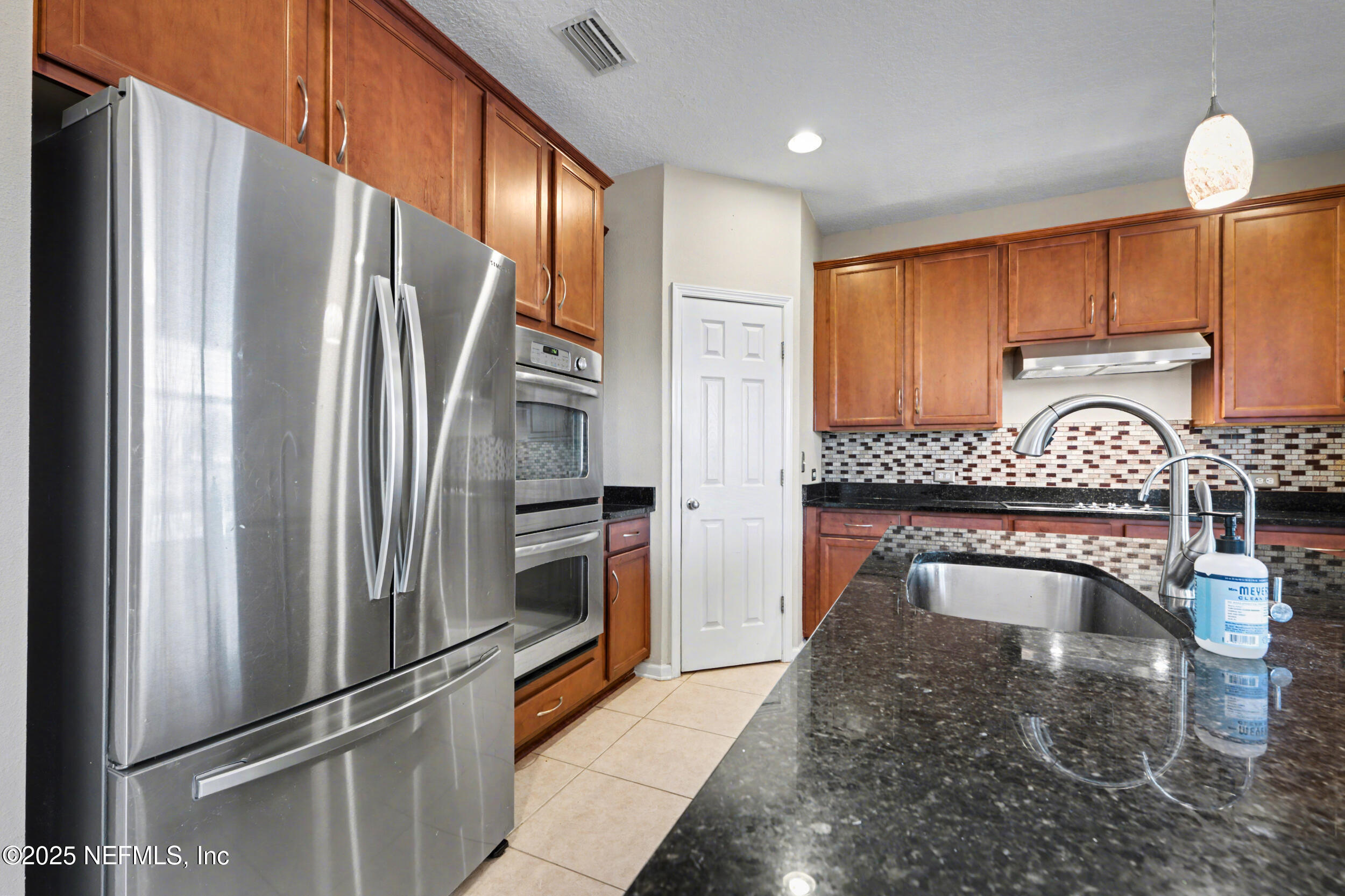 13697 Goodson Place Jacksonville, FL 32226 - Photo 8 of 28 a kitchen with stainless steel appliances granite countertop a refrigerator a stove and a sink with wooden floor