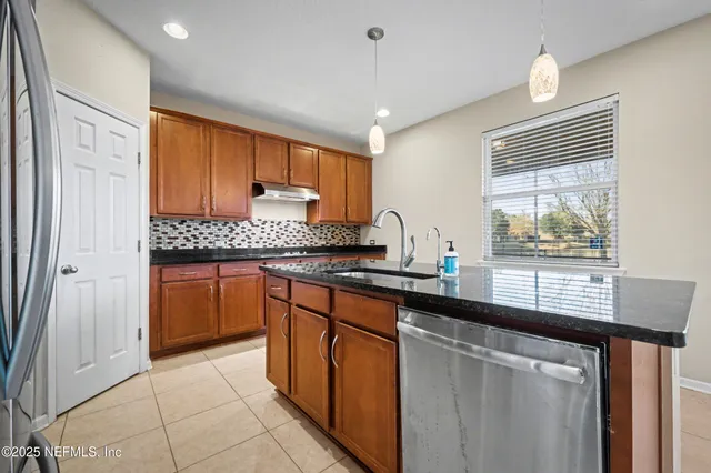 a kitchen with stainless steel appliances granite countertop a stove a sink and a refrigerator
