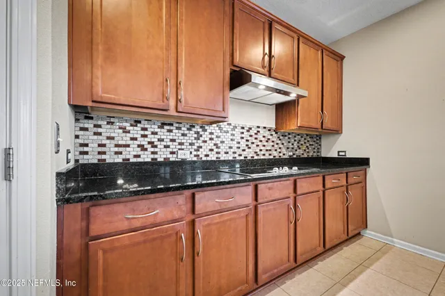 a kitchen with granite countertop cabinets and window