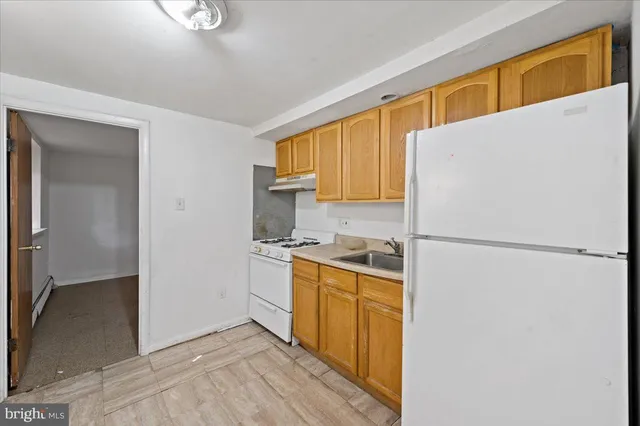 a kitchen with a refrigerator a stove top oven a sink and dishwasher