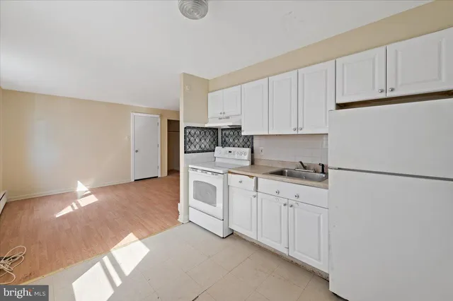 a kitchen with granite countertop white cabinets and white appliances