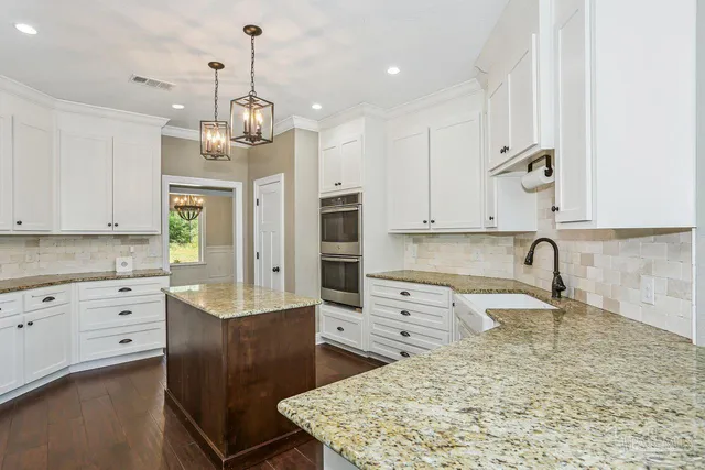 a kitchen with stainless steel appliances granite countertop a refrigerator sink and stove