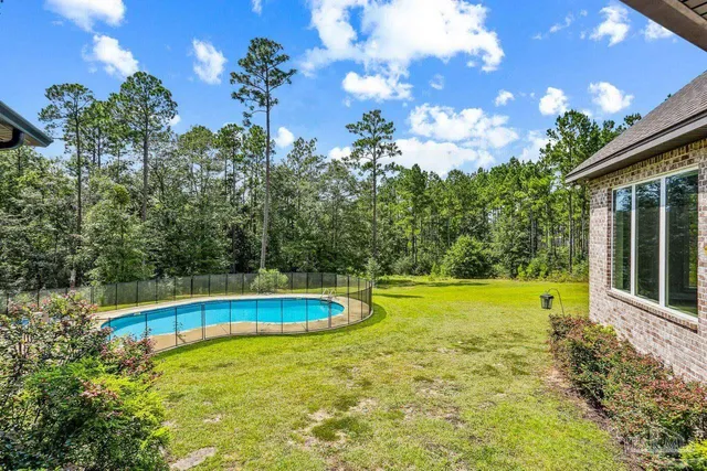a aerial view of a house with swimming pool and large trees