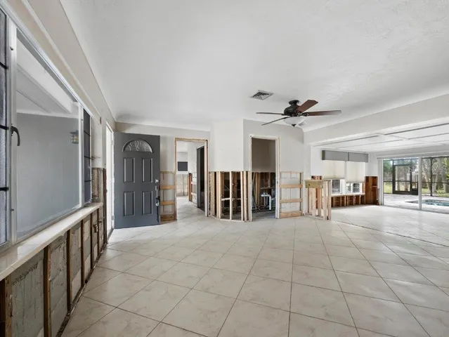a living room with stainless steel appliances furniture a window and a flat screen tv