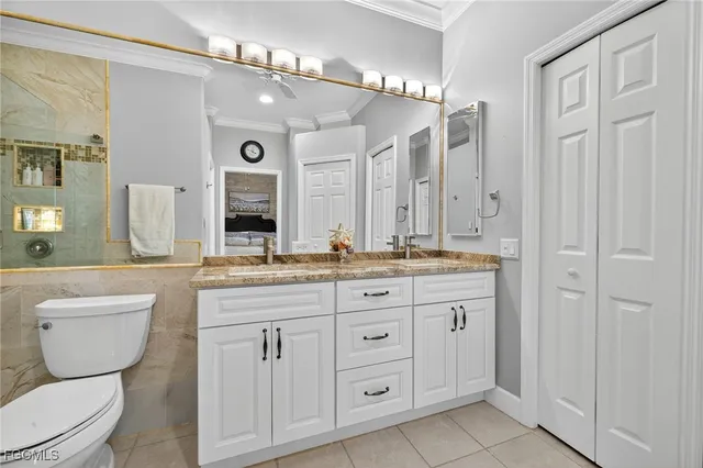 a bathroom with a granite countertop sink a toilet a mirror and shower