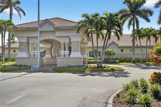 a view of a white house with a small yard and palm trees