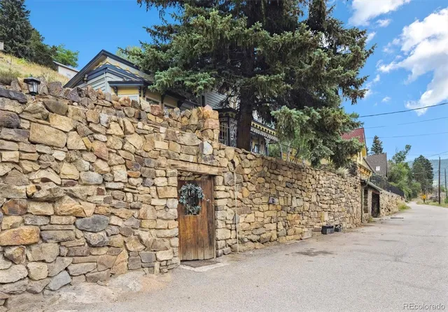 a stone house with a tree in front of it