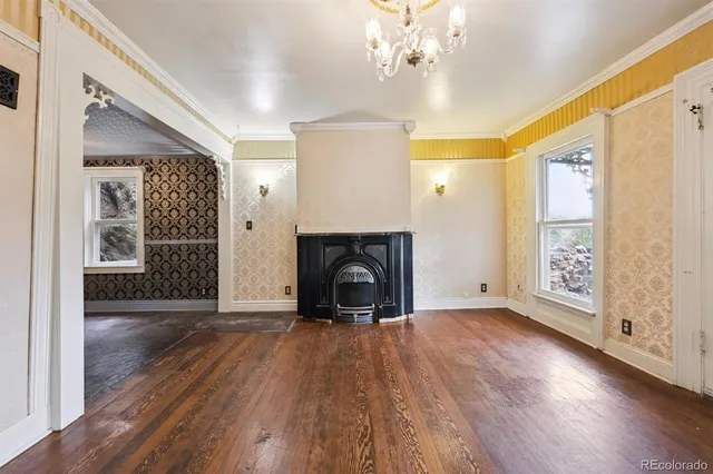 a view of a livingroom with wooden floor fireplace and a window