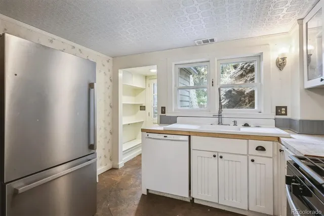 a kitchen with white cabinets and sink