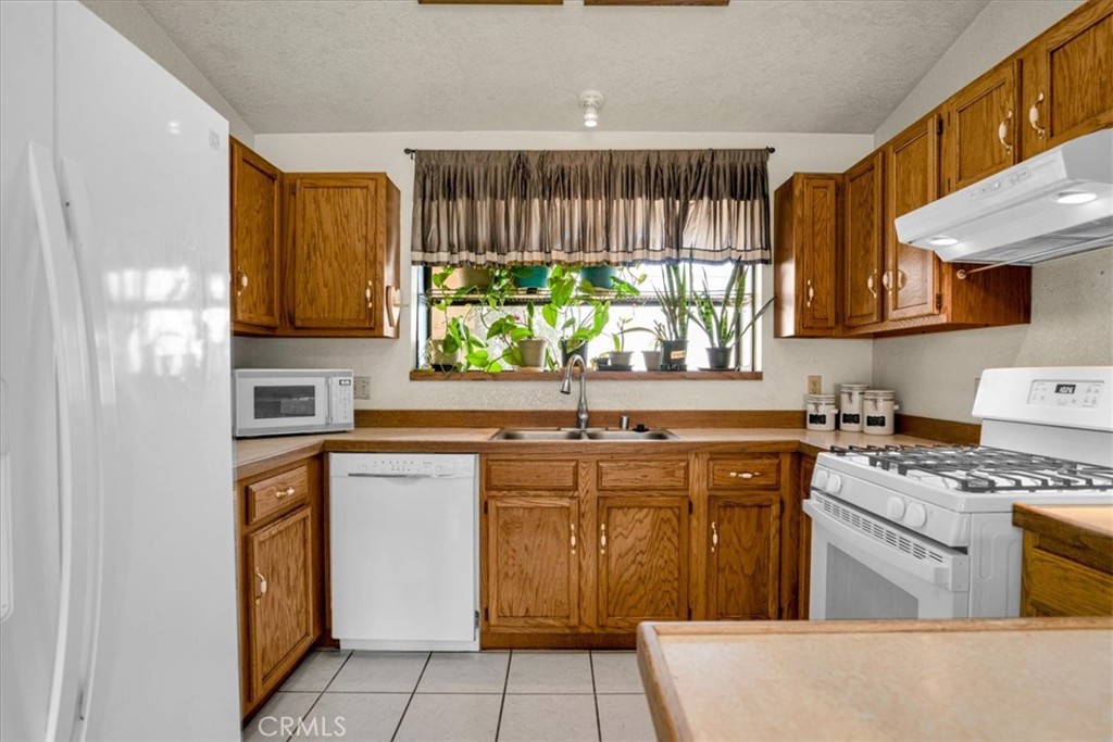72775 2 Mile Road Twentynine Palms, CA 92277 - Photo 12 of 55 a kitchen with stainless steel appliances granite countertop a stove a sink and a microwave