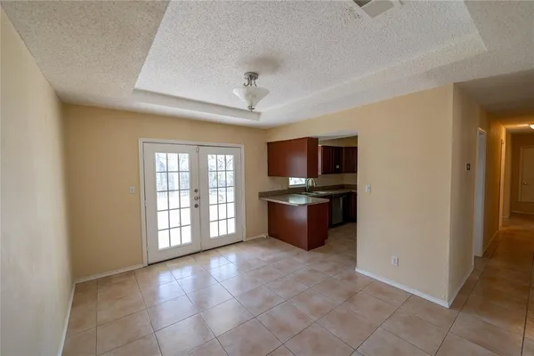 a view of kitchen with granite countertop cabinets and refrigerator