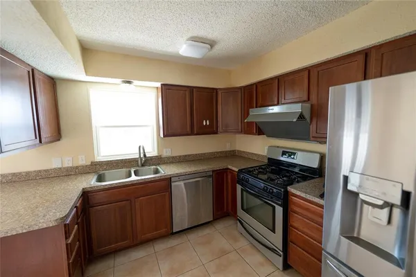 a kitchen with stainless steel appliances a sink stove and refrigerator
