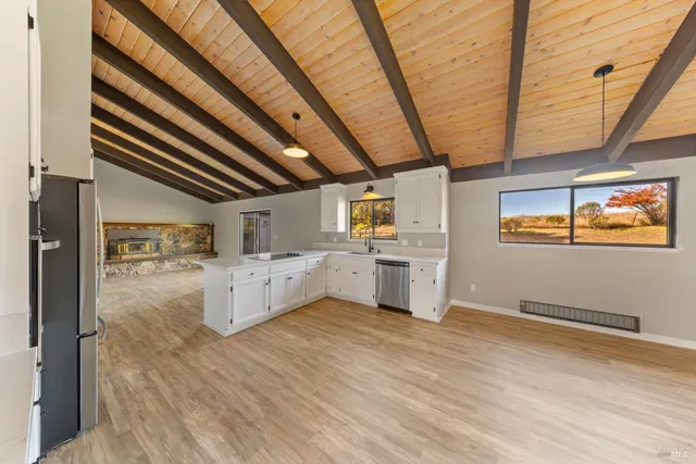 a kitchen with refrigerator and wooden floor