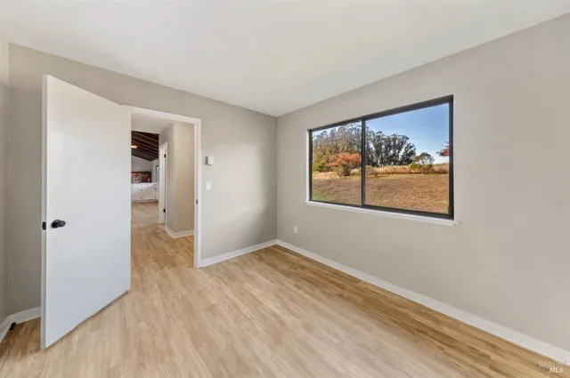 an empty room with wooden floor and closet