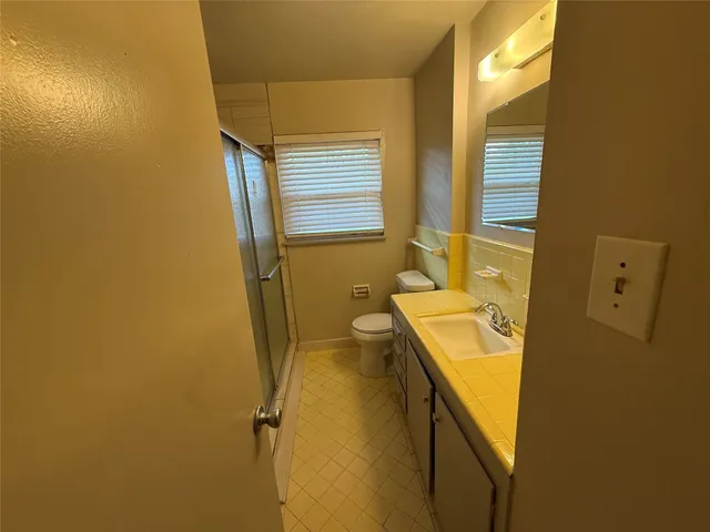 a bathroom with a sink and mirror with bathtub