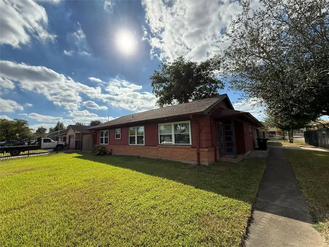 front view of a house with yard and large trees