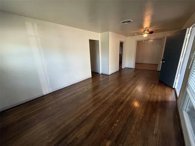 a view of empty room with wooden floor