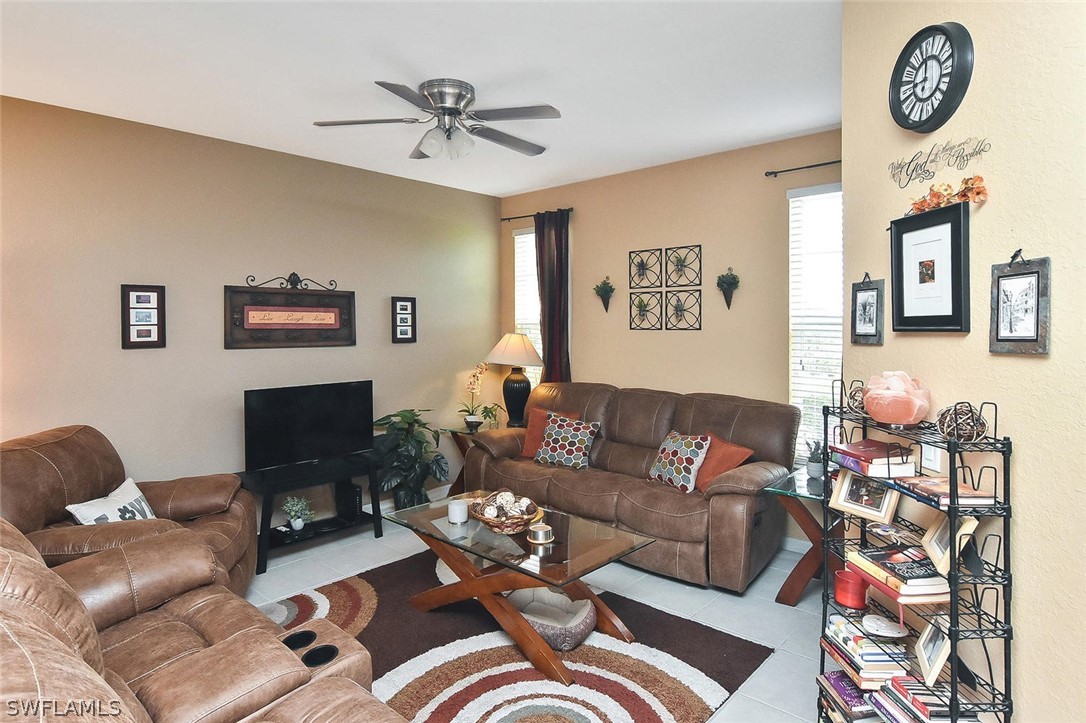 3840 Cherrybrook Loop Fort Myers, FL 33966 - Photo 14 of 32 a living room with furniture a clock on wall and a window