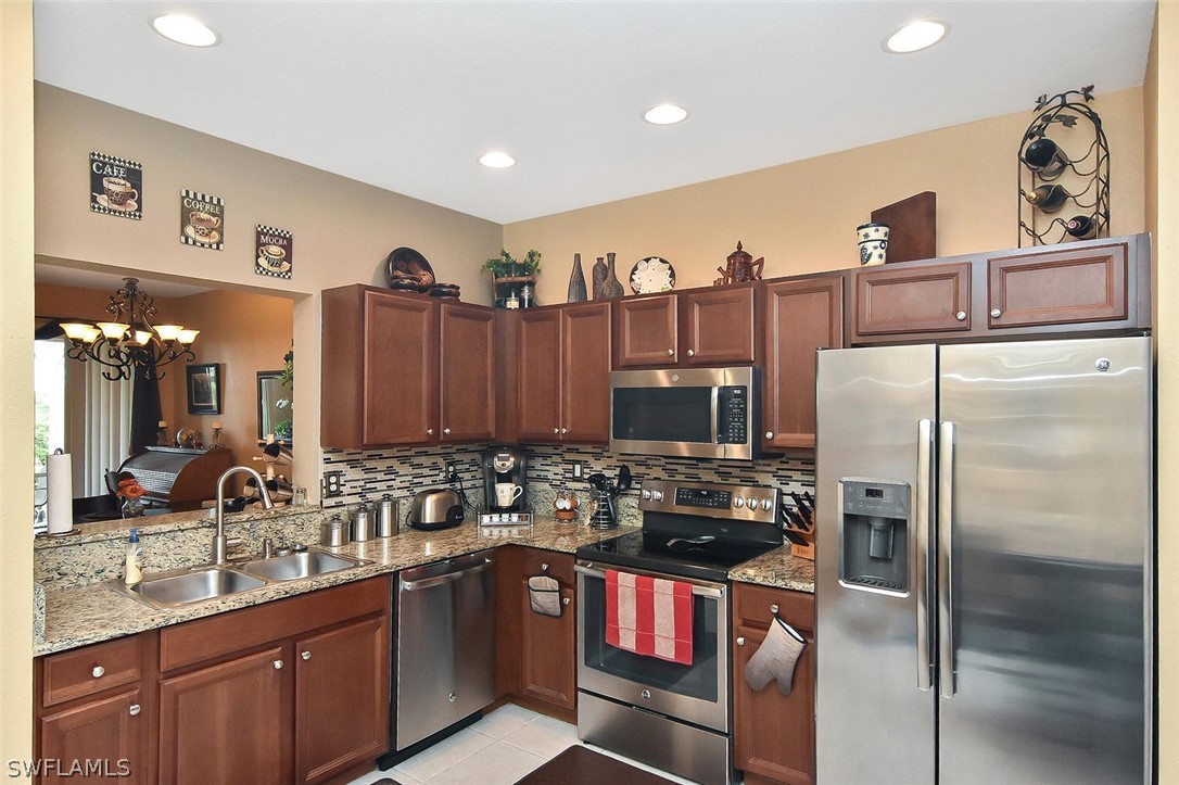 3840 Cherrybrook Loop Fort Myers, FL 33966 - Photo 8 of 32 a kitchen with stainless steel appliances granite countertop a refrigerator a sink and a stove