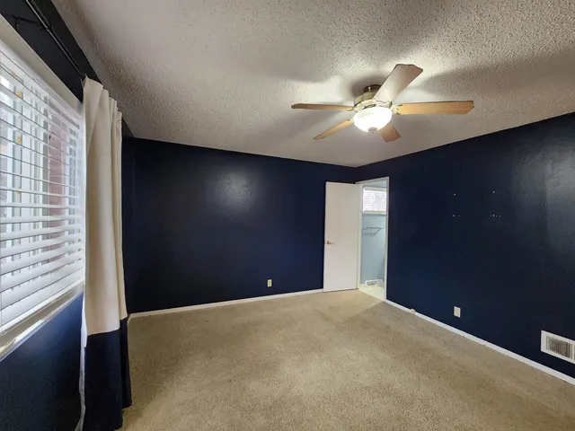 a big room with closet and a ceiling fan