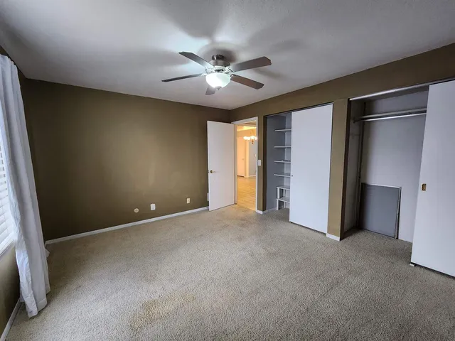 a view of an empty room with a ceiling fan