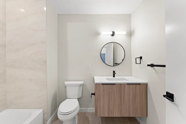 a bathroom with a toilet sink and a mirror