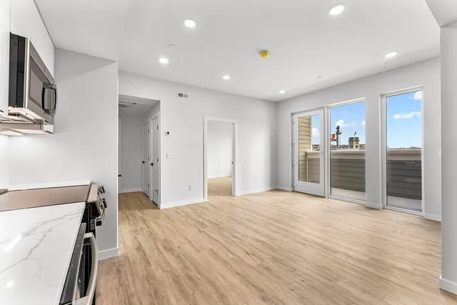 a large bedroom with a bed and a view of kitchen