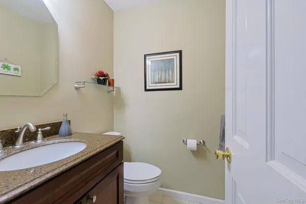a bathroom with a granite countertop sink and a toilet