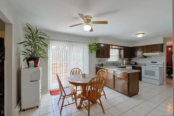 a kitchen with stainless steel appliances a white table chairs and a refrigerator