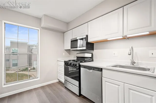 a kitchen with stainless steel appliances granite countertop a stove a sink and a microwave