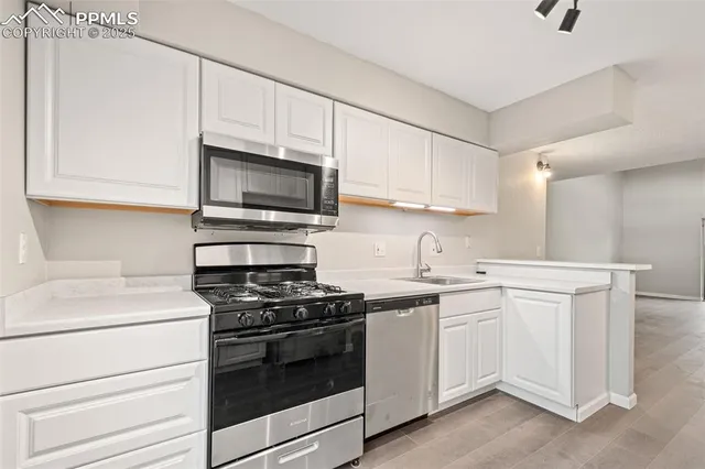 a kitchen with white cabinets stainless steel appliances and sink