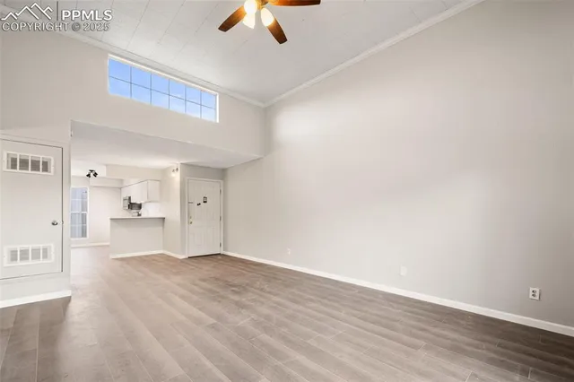 a view of empty room with wooden floor