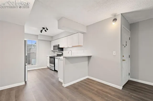 a kitchen with white cabinets and stainless steel appliances