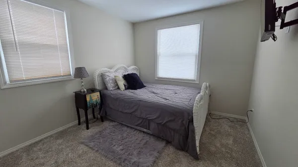 a bed sitting in a bedroom next to a window