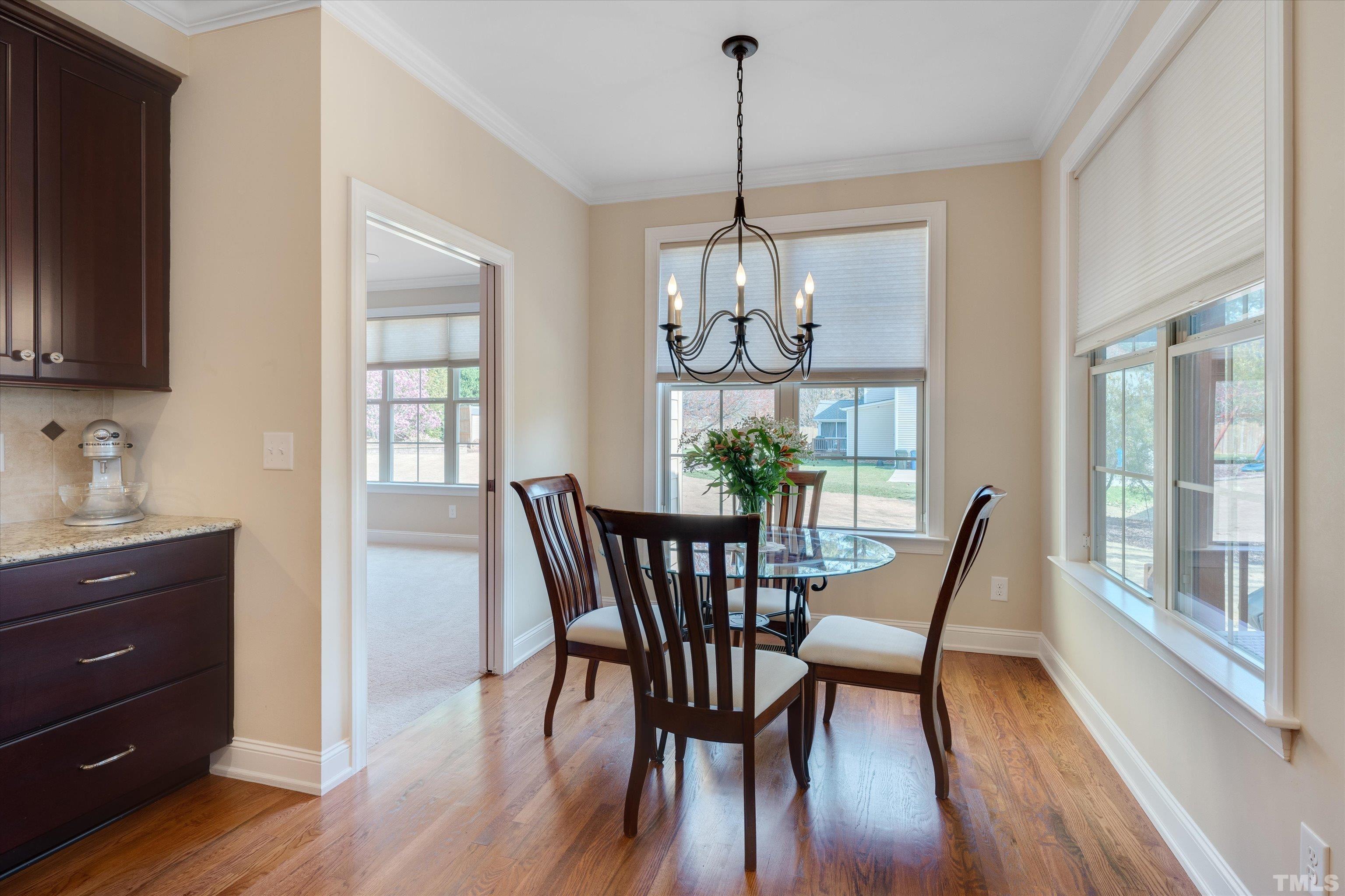 2704 Full Circle Raleigh, NC 27613 - Photo 12 of 32 a view of a dining room with furniture a chandelier and wooden floor