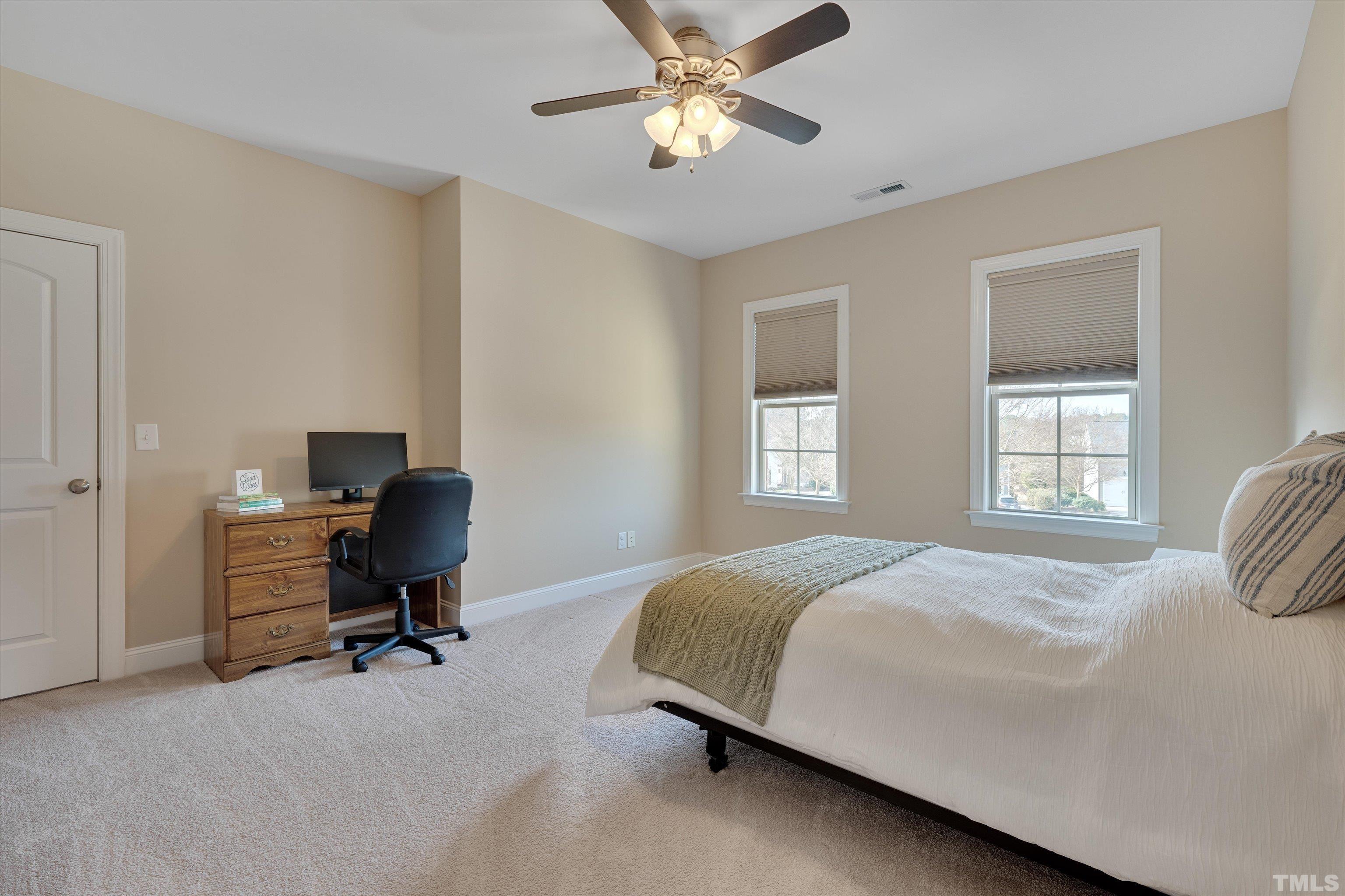 2704 Full Circle Raleigh, NC 27613 - Photo 23 of 32 a bedroom with a bed a desk and chair next to a window