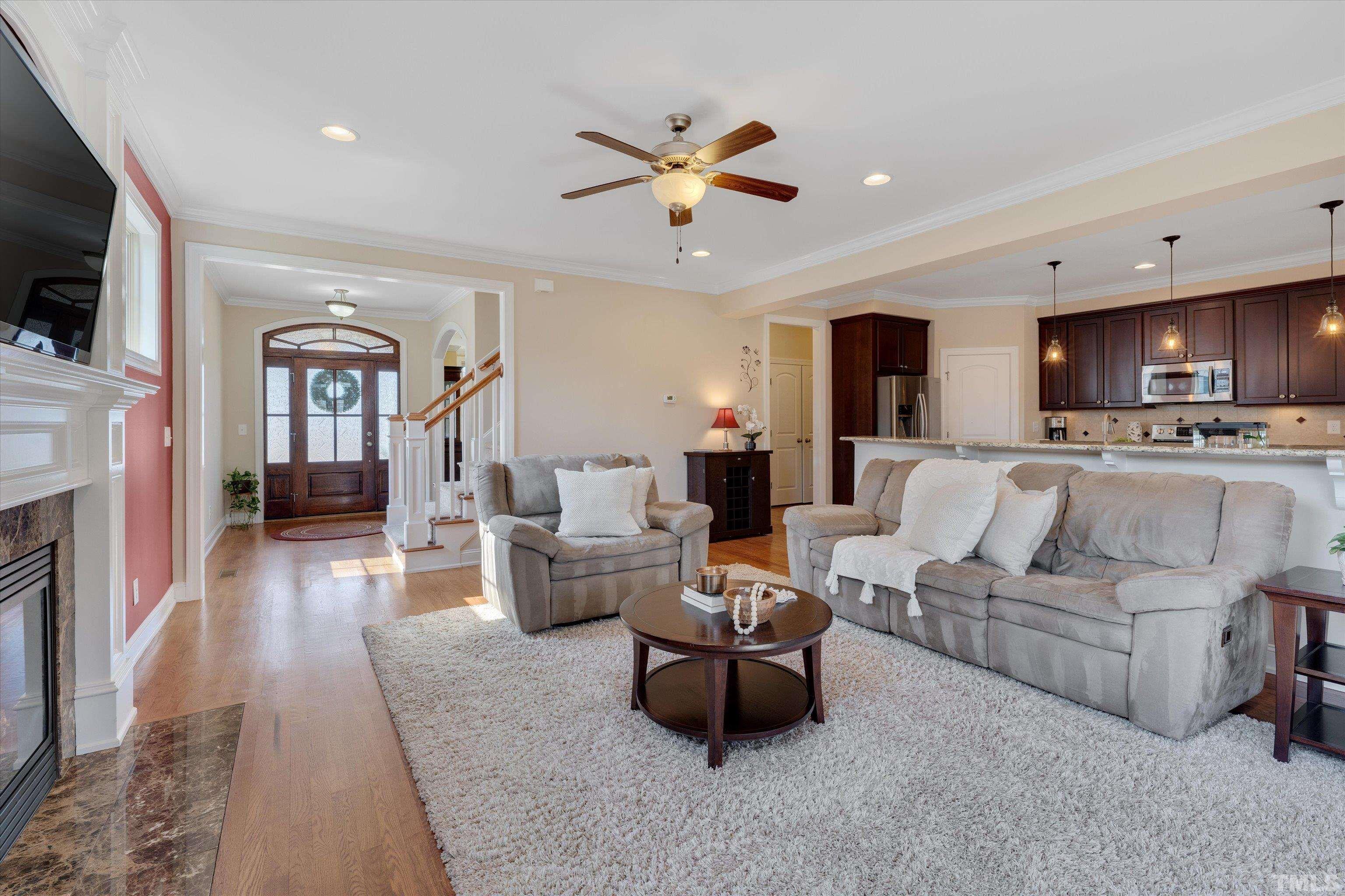 2704 Full Circle Raleigh, NC 27613 - Photo 8 of 32 a living room with furniture a flat screen tv and a fireplace