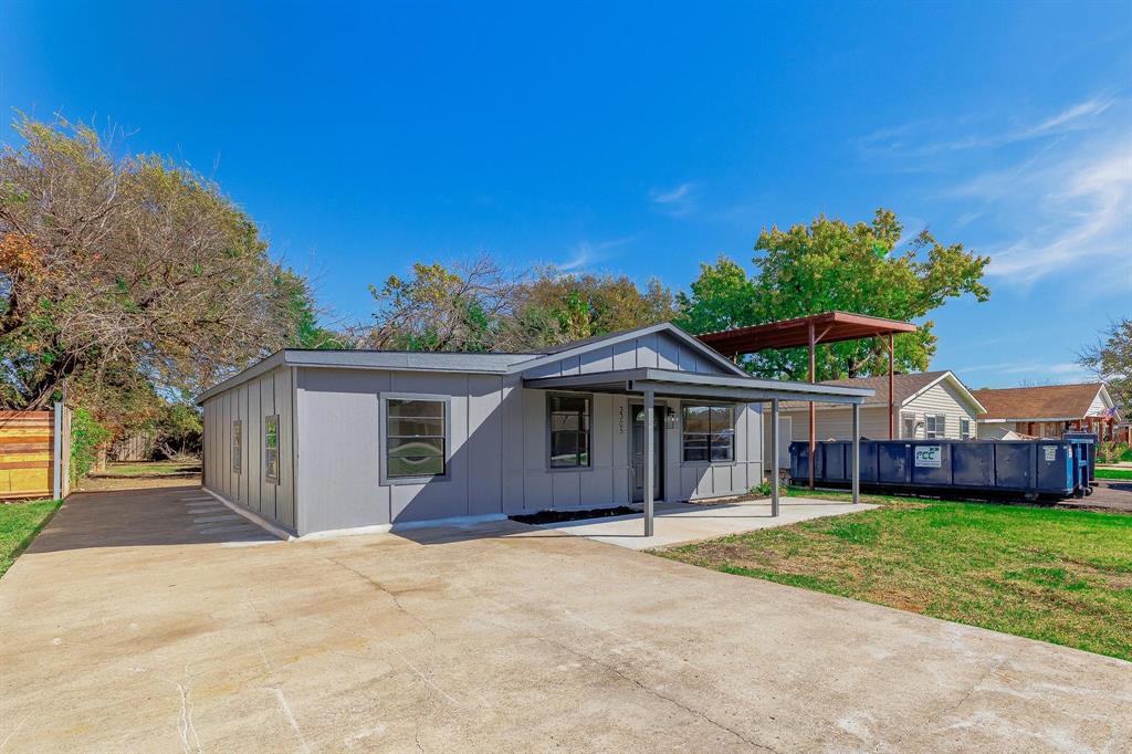 View of front facade with driveway, board and batten siding, and a swimming pool