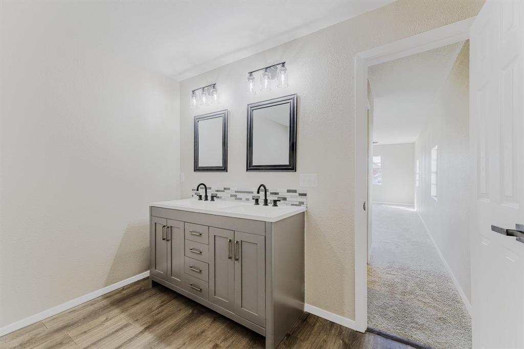 3305 Elm Grove Road Rowlett, TX 75098 - Photo 14 of 24 Bathroom featuring double vanity, light wood-style flooring, and a textured wall
