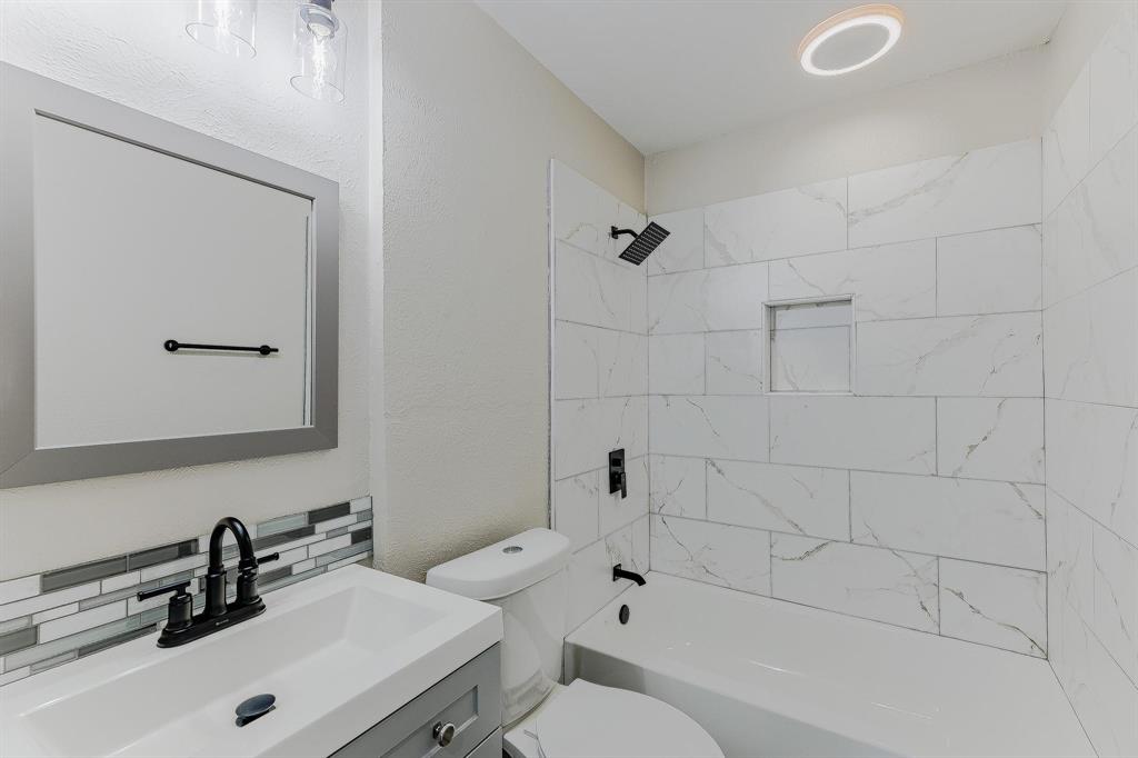 3305 Elm Grove Road Rowlett, TX 75098 - Photo 17 of 24 Bathroom with vanity, bathing tub / shower combination, a textured wall, and backsplash